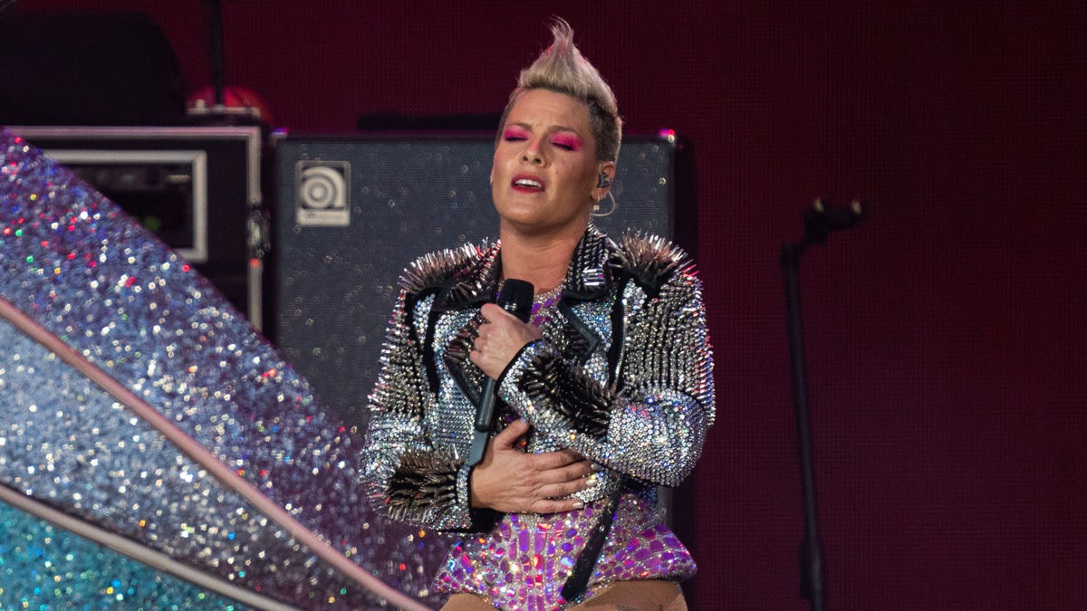 Singer Pink closes her eyes and holds her hands to her chest while on stage in England