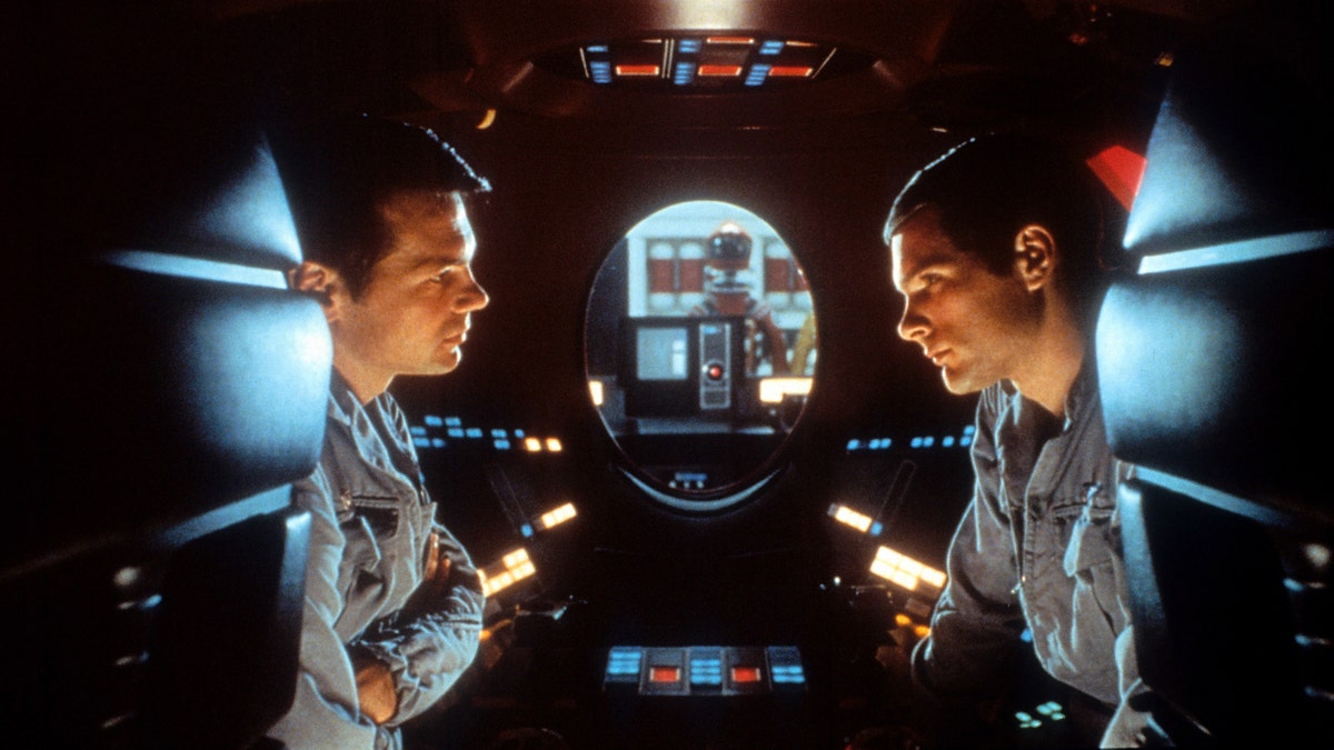 Gary Lockwood and Keir Dullea talk to each other during a scene in what looks like a spaceship from "2001: A Space Odyssey"
