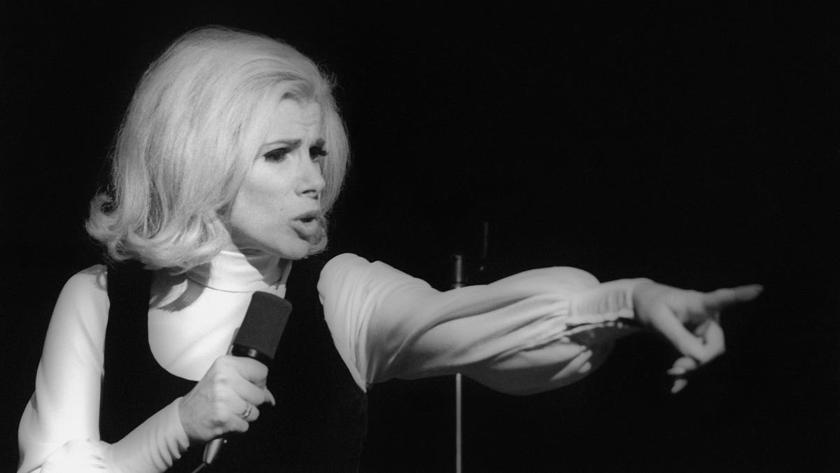 Black and white photo of Joan Rivers on stage pointing