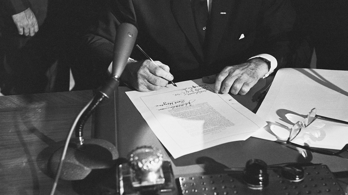 1964 کے شہری حقوق ایکٹ پر دستخط کرنے کے بعد ہاتھ
