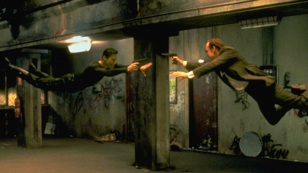Keanu Reeves as Neo and Hugo Weaving as computerized Agent Smith battle in the air in "The Matrix"