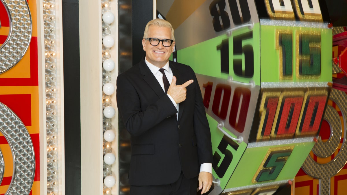 Drew Carey poses with the showcase showdown wheel on The Price is Right