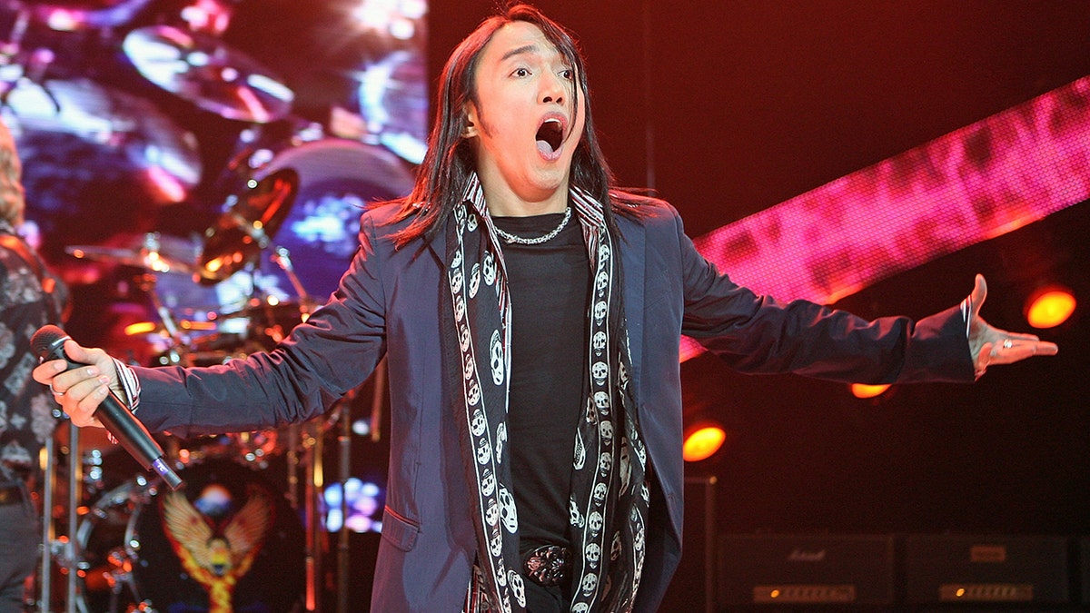 Arnel Pineda performing on stage and looking surprised