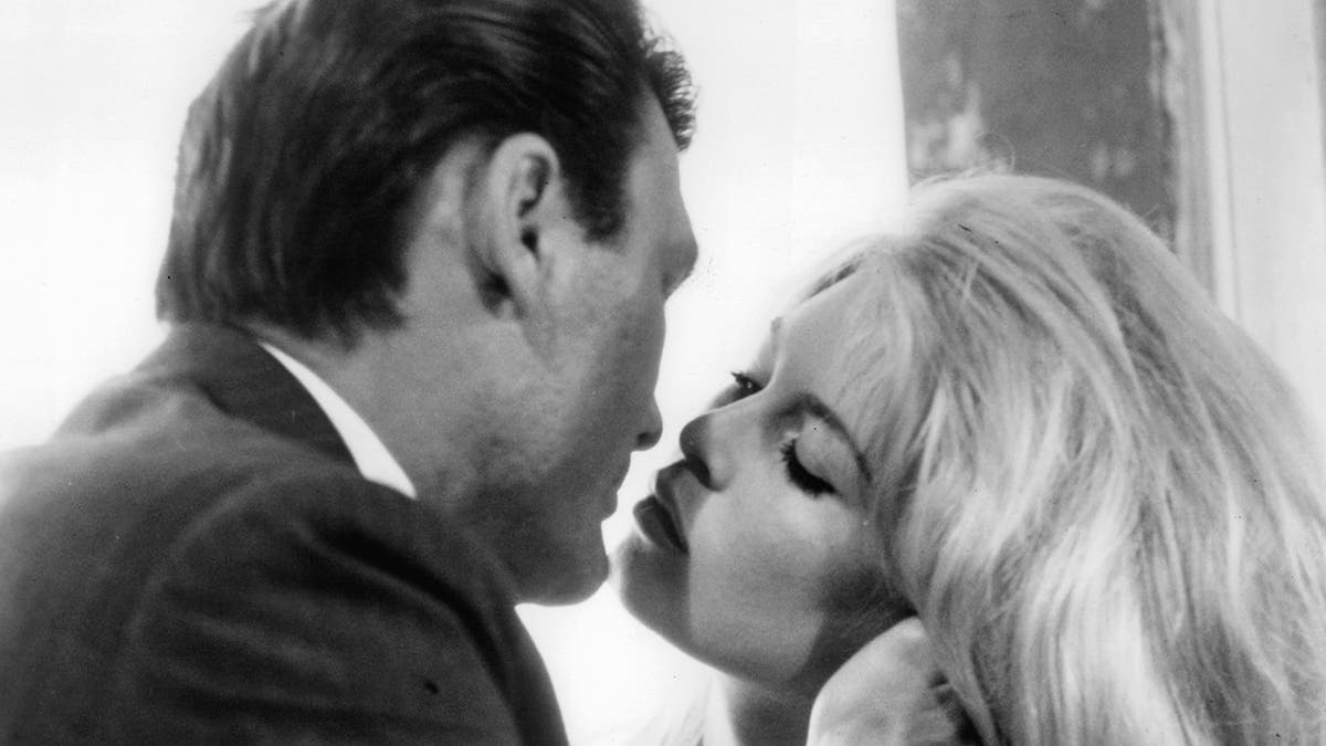 Jack Palance kissing Brigitte Bardot