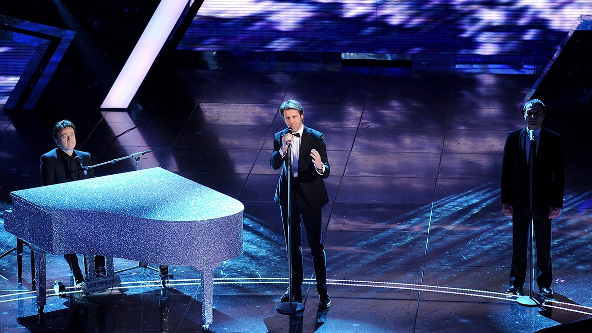 Emanuele Filiberto on stage singing in a tux