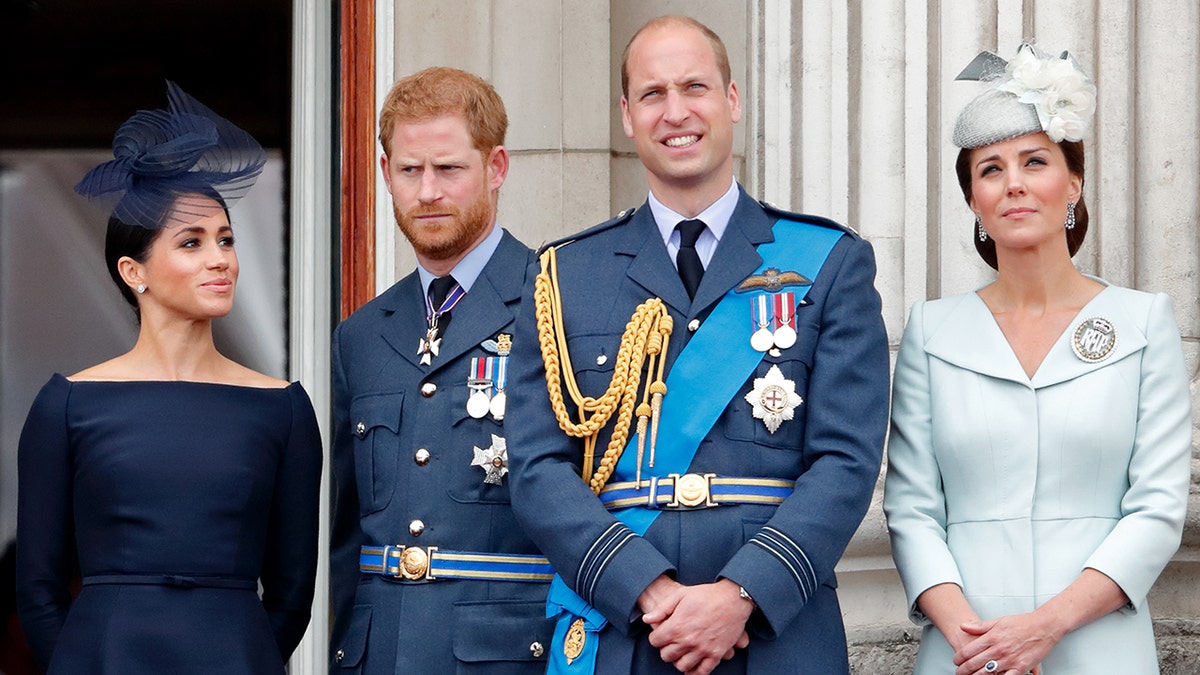Meghan Markle, Prince Harry, Prince William and Kate Middleton in regal royal clothing standing on the balcony of Buckingham palace