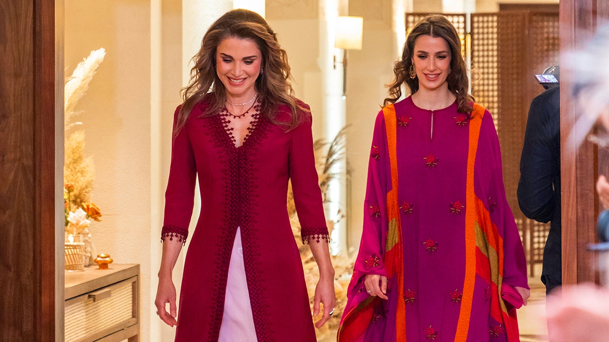 Queen Rania and her daughter-in-law Princess Rajwa wearing burgundy gowns at a henna party