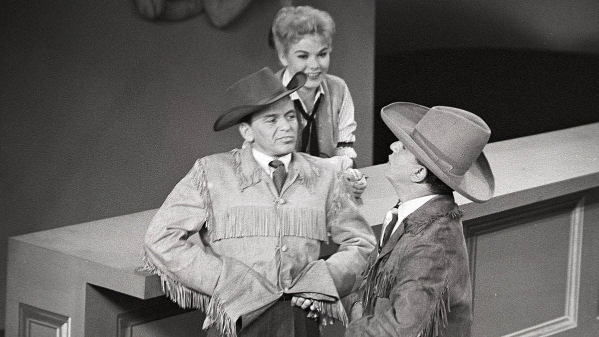 Frank Sinatra and Louis Prima filming a skit in cowboy gear