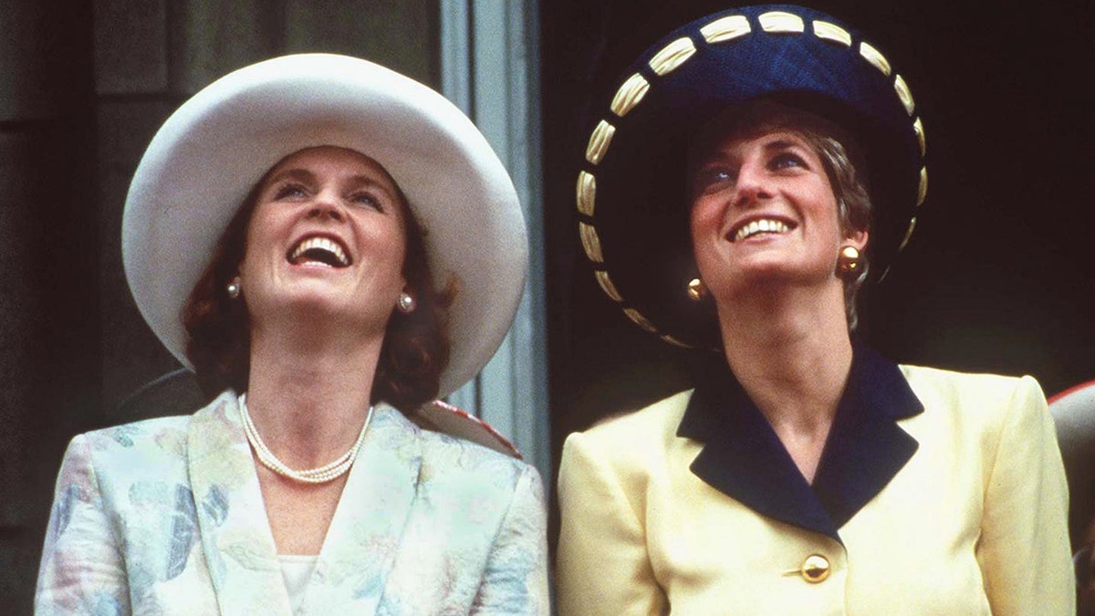 Sarah Ferguson and Princess Diana looking up with their hats on