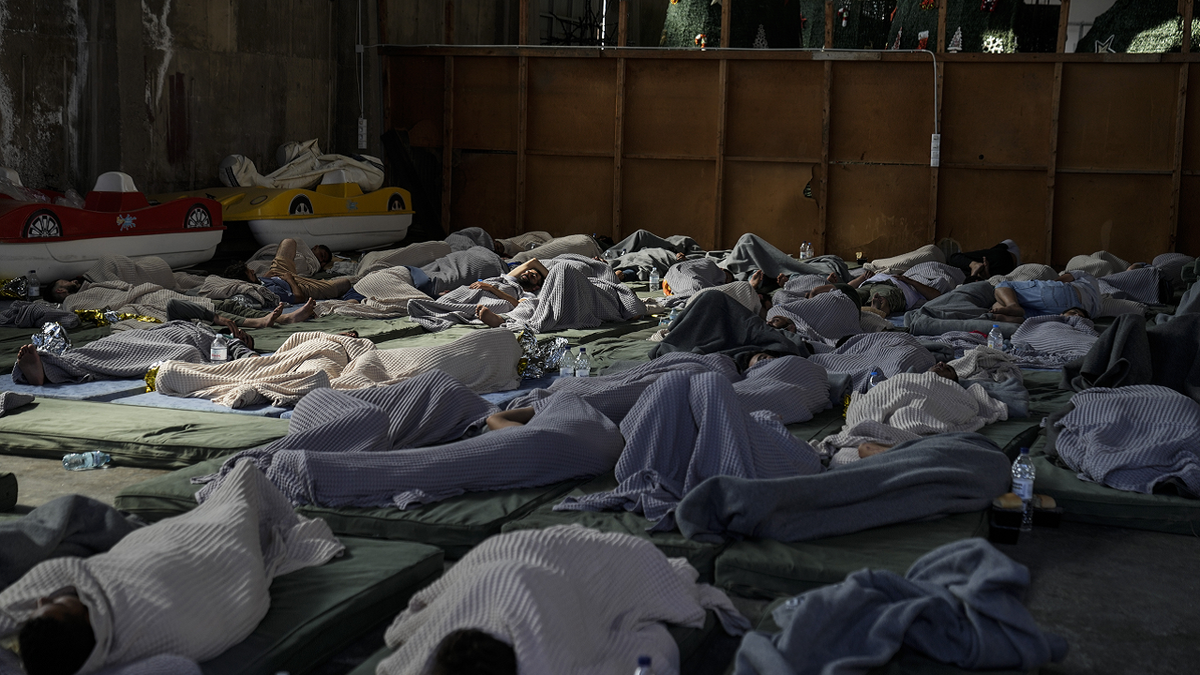 Greece migrant boat sinking survivors sleep in warehouse
