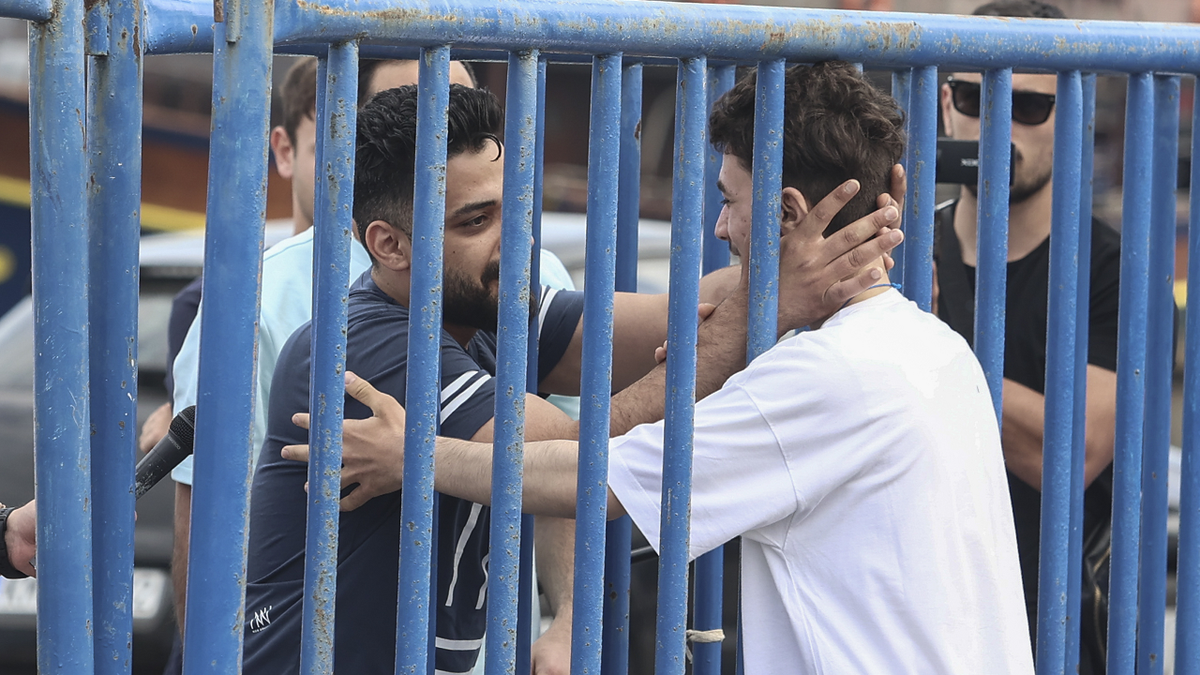 Migrant from Syria embraces brother after surviving sinking of boat
