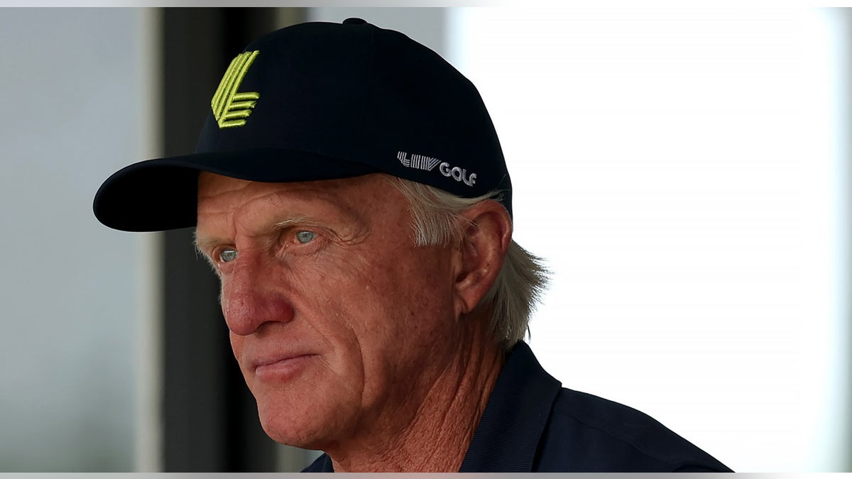 Greg Norman looks on