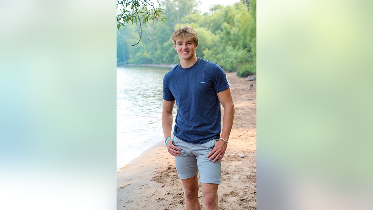 Jordan DeMay posing by a lake