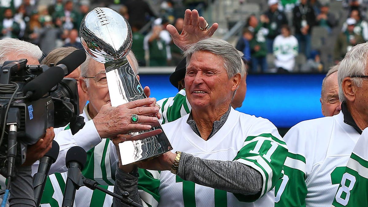 Jim Turner gets handed a Super Bowl trophy