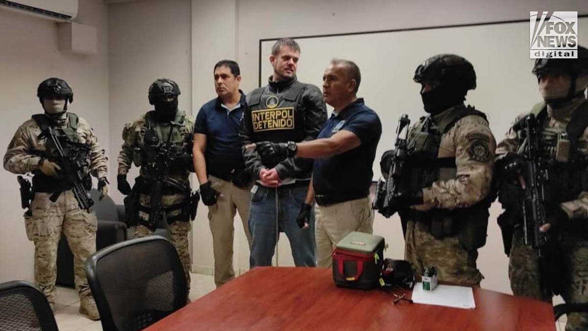 Joran van der Sloot is surrounded by armed guards.