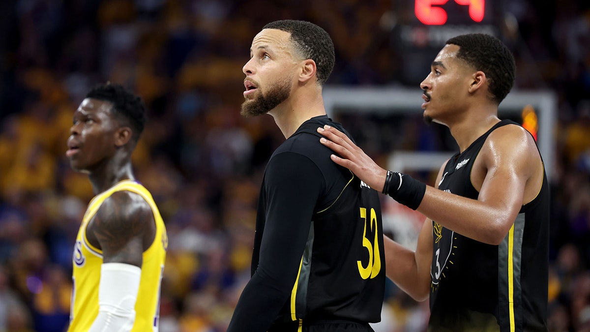 Stephen Curry and Jordan Poole look on during a game