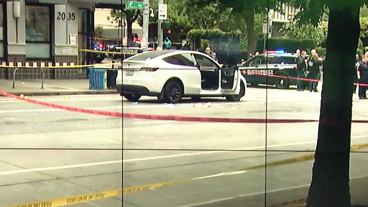 Crime scene tape in front of white Tesla with it's passenger door open.