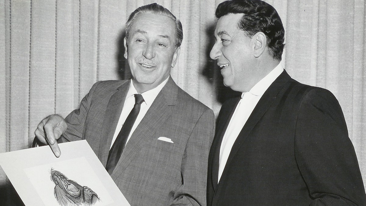 Louis Prime looking a a drawing of King Louie being held by Walt Disney
