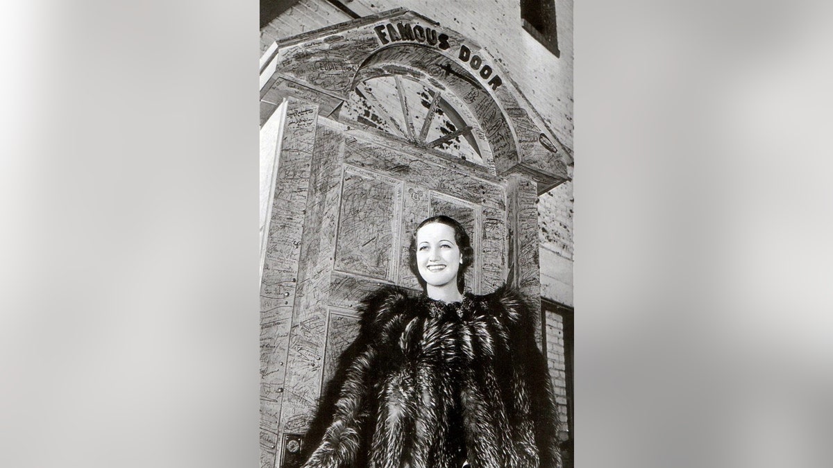 Actress Dorothy Lamour wearing a fur coat in front of The Famous Door