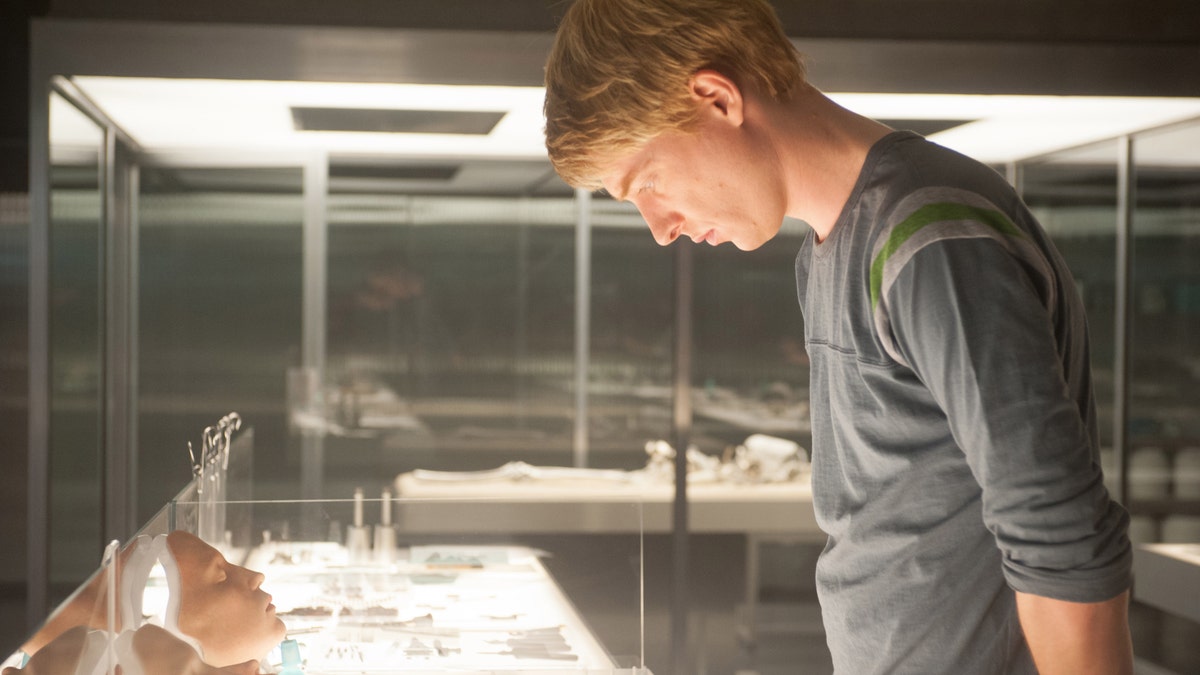 Domhnall Gleeson looks down at faces in a scene from "Ex Machina"