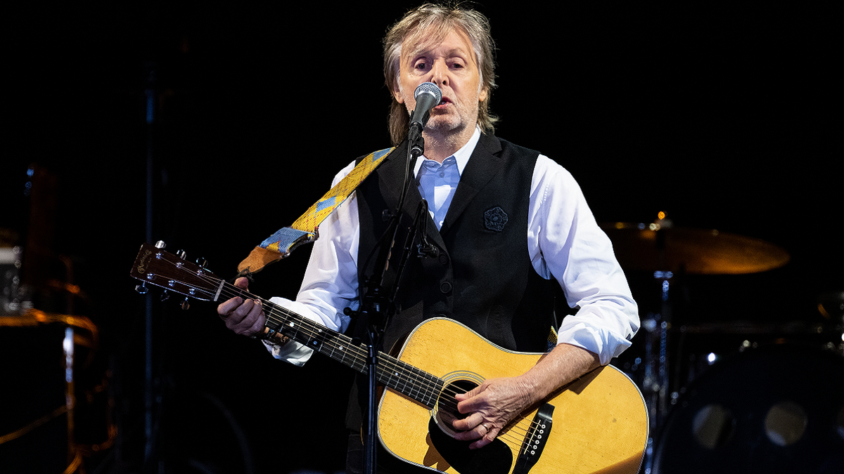 Paul McCartney performs with guitar