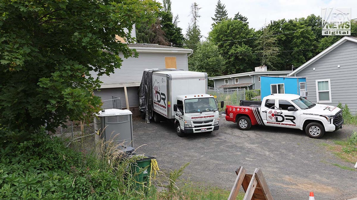 Trucks labeled Disaster Recovery parked as workers went in and out of the King Road home in Moscow idaho