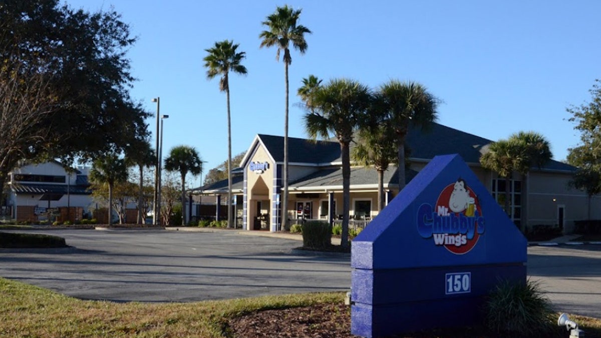 The exterior of Mr. Chubby's with palm trees flanking the entrance.