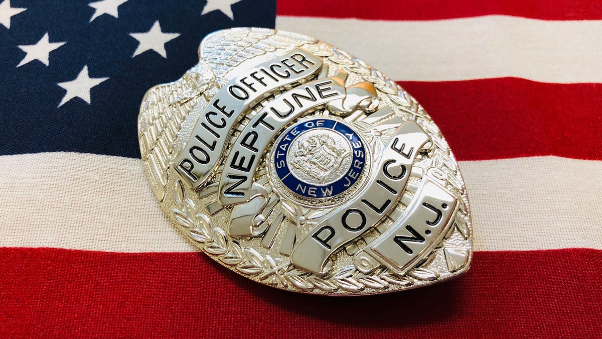 Neptune Township police badge in front of American Flag