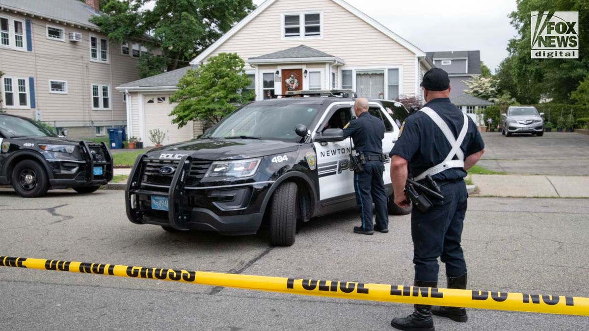 Police officers gather outside of the home where a triple homicide occurred in Newton, Massachusetts