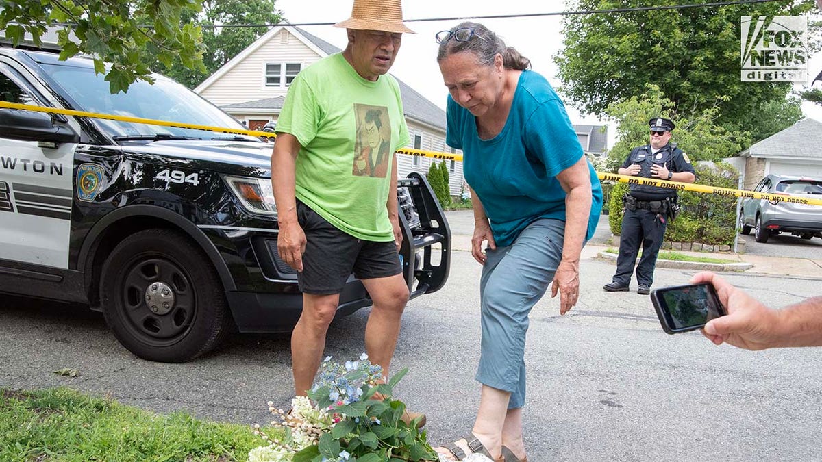 A couple leaves flowers outside of a Massachusetts house