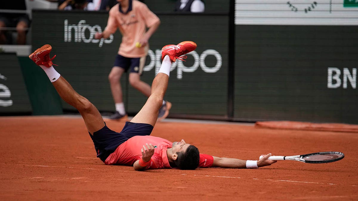Novak Djokovic falls to the ground