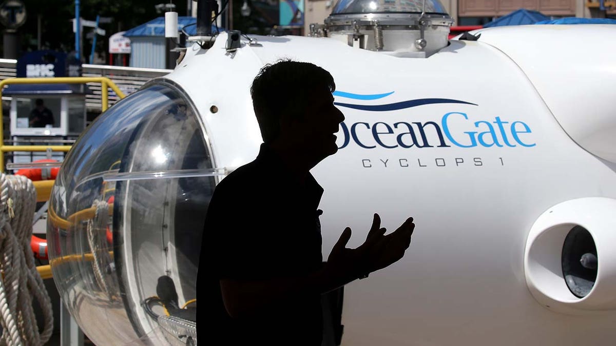 A man speaks in front of an OceanGate submersible