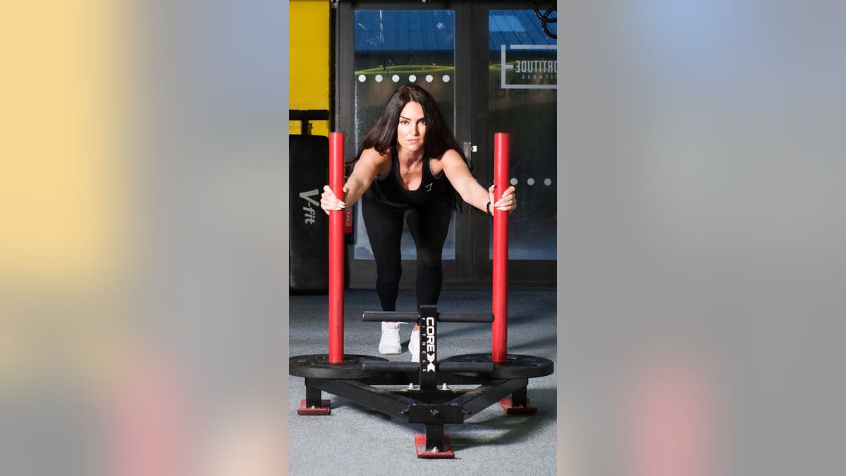 Fit personal trainer works out in a gym