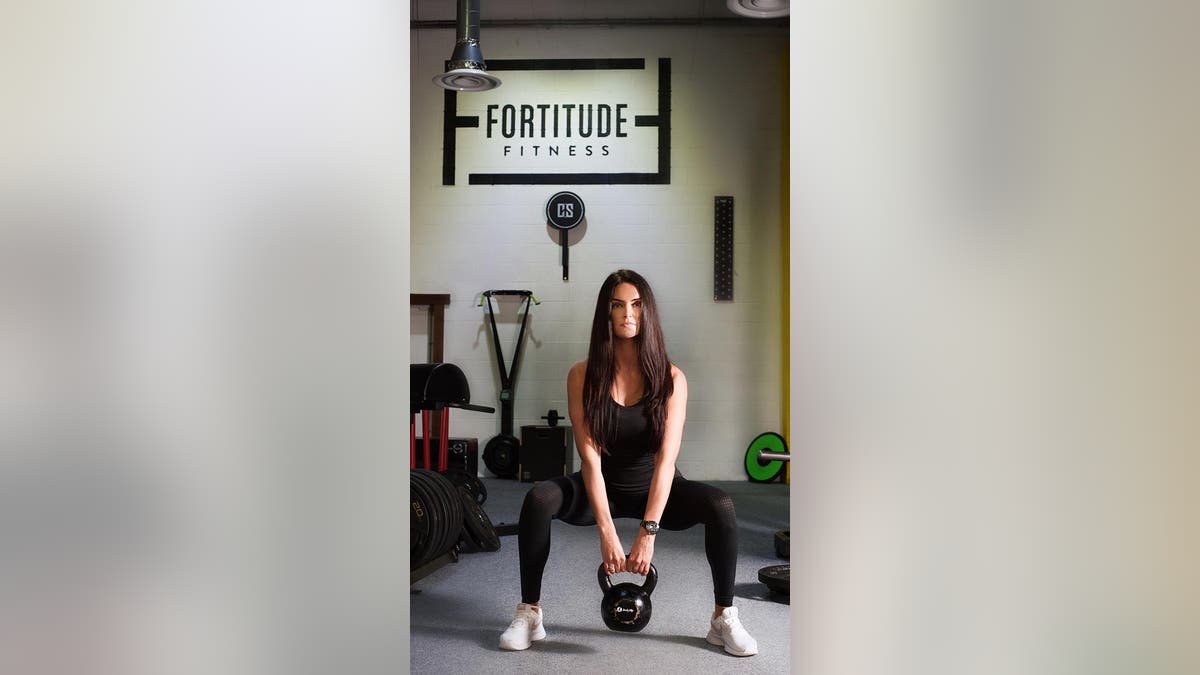 Fit personal trainer works out in a gym