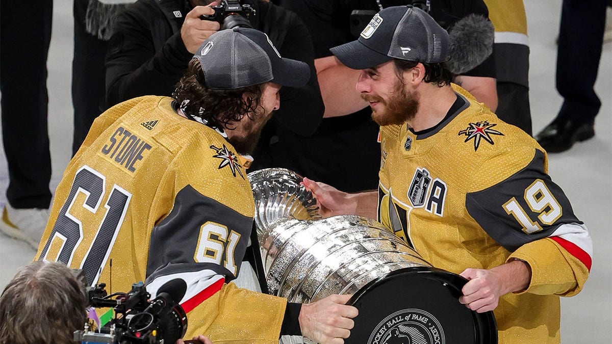 Mark Stone hands cup to Reilly Smith