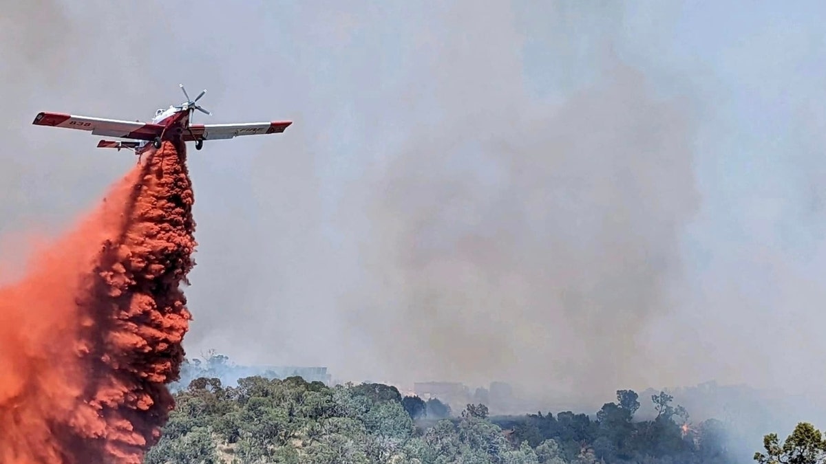 A plane drops retardant on the Spring Creek Fire