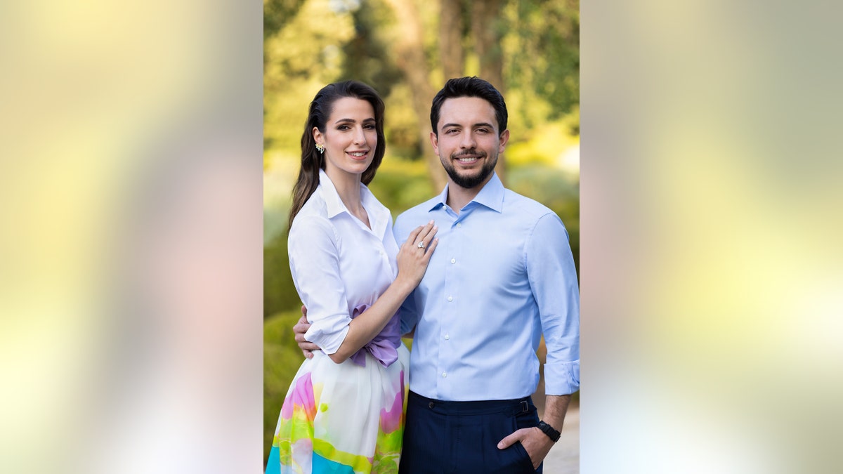Princess Rajwa in a white blouse and colorful skirt next to Crown Prince Hussein in a light blue shirt