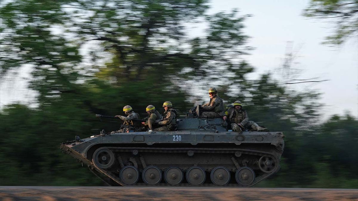 Ukrainian soldiers ride on a BMP infantry fighting vehicle toward Bakhmut,