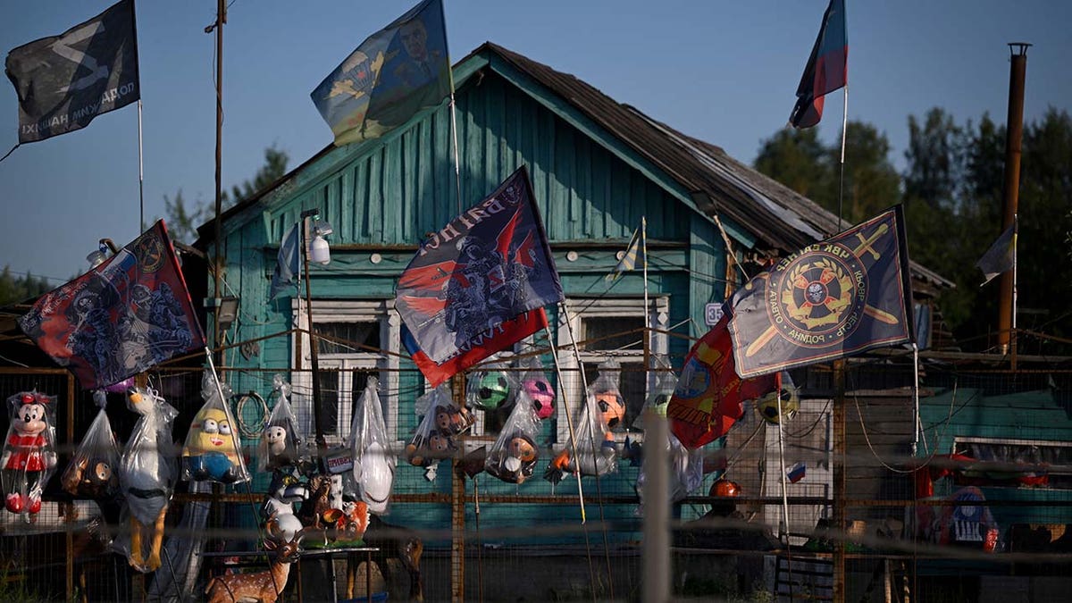 flags, including those of the Wagner private mercenary group, for sale on a road outside Moscow.