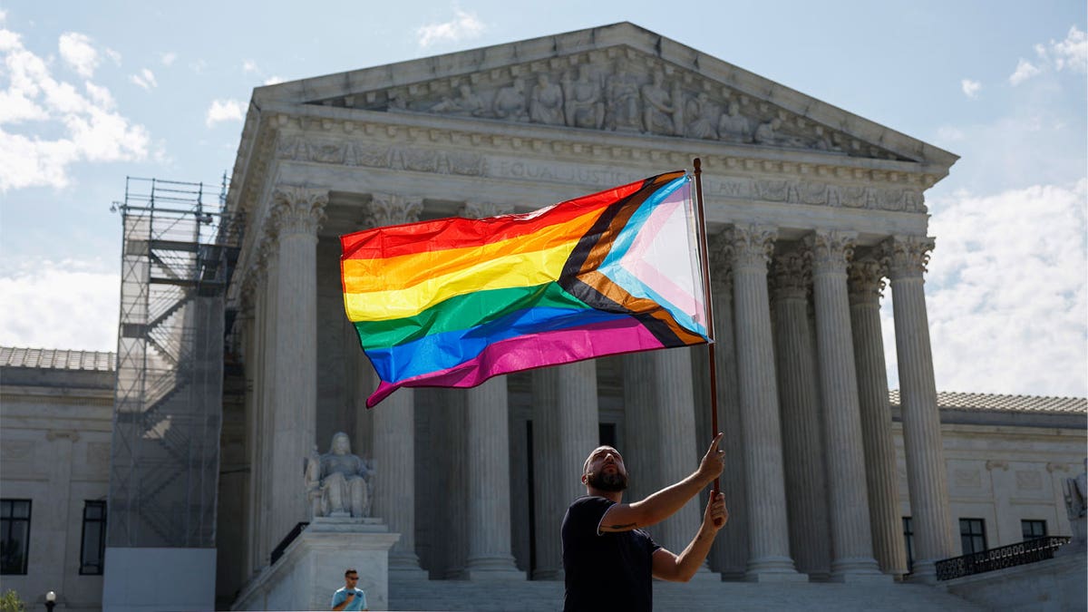 man waves Pride flag outside SCOTUS