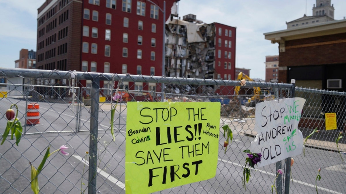 Flowers and signs are posted at the where on Sunday an apartment building partially collapsed in Davenport