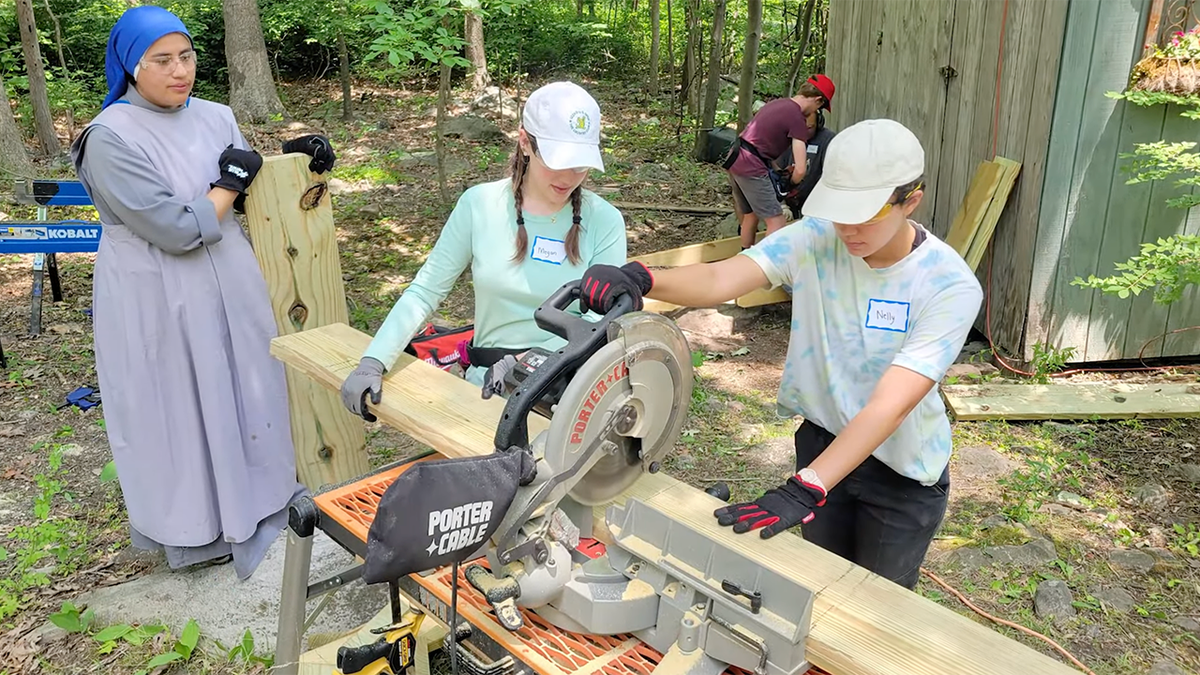 Two girls working a saw
