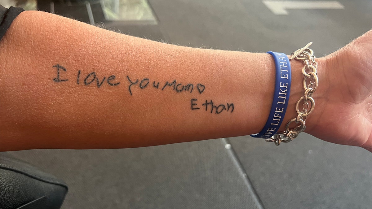 A forearm tattoo reading "I love you mom."