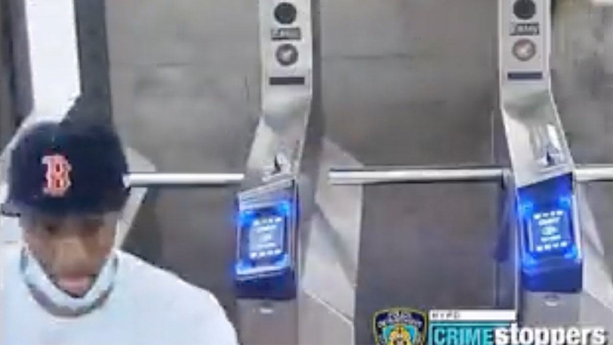 Slashing suspect wearing Boston Red Sox hat walks away from turnstile at NYC subway platform