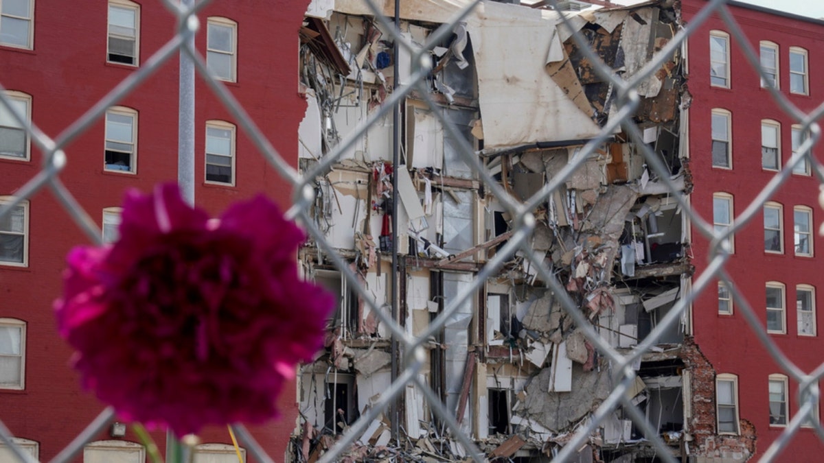 A flower hangs where on Sunday an apartment building partially collapsed in Davenport