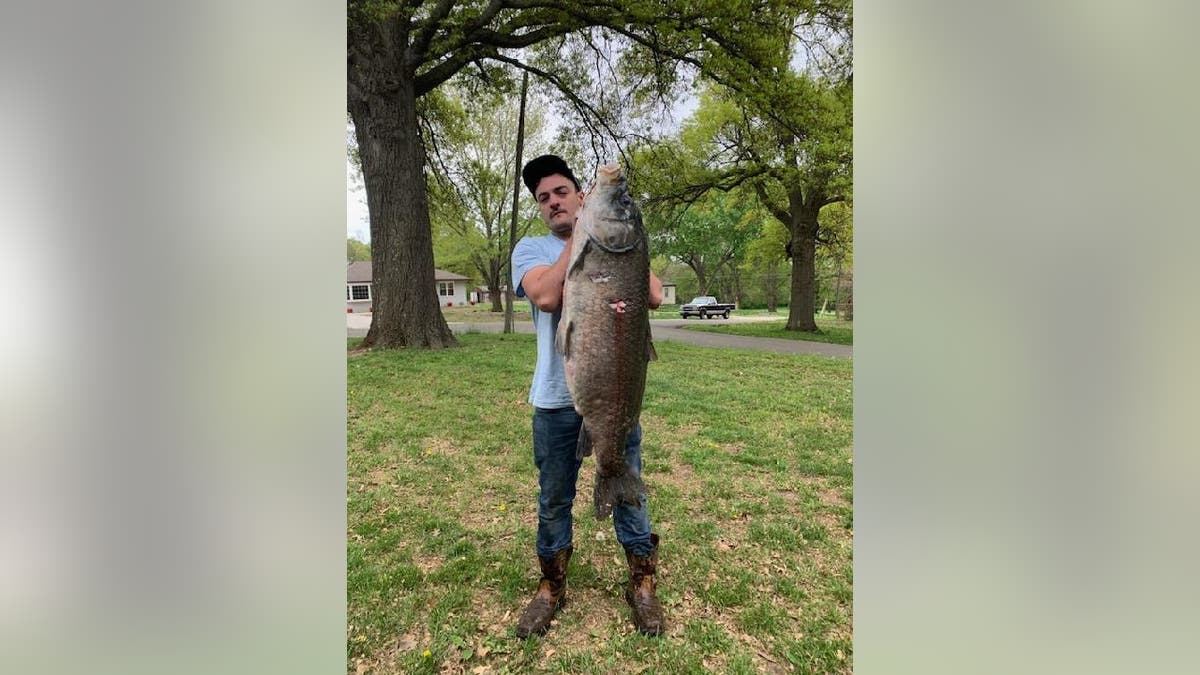 Thayne Miller holds up his 64.75-pound smallmouth buffalo.