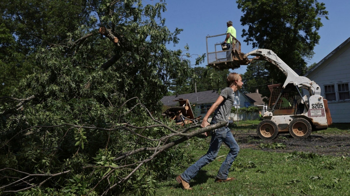 An Arkansas man helps move debris from his home