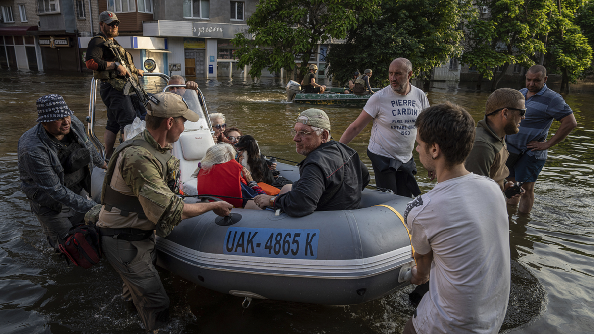 Ukrainian servicemen rescue people by boat after dam collapse