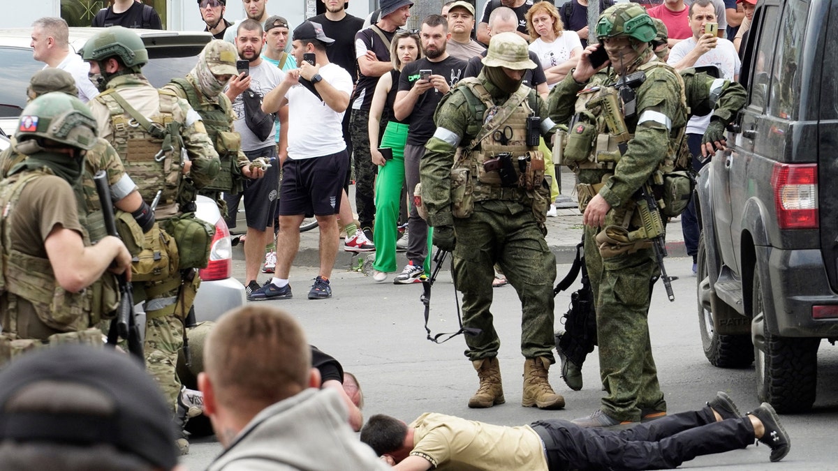 TOPSHOT - Members of Wagner group detain a man in the city of Rostov-on-Don, on June 24, 2023. President Vladimir Putin on June 24, 2023 said an armed mutiny by Wagner mercenaries was a "stab in the back" and that the group's chief Yevgeny Prigozhin had betrayed Russia, as he vowed to punish the dissidents. Prigozhin said his fighters control key military sites in the southern city of Rostov-on-Don. (Photo by STRINGER / AFP) (Photo by STRINGER/AFP via Getty Images)