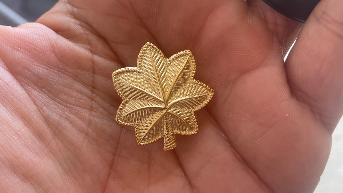 Man holds the golden leaf pin of major in his hand
